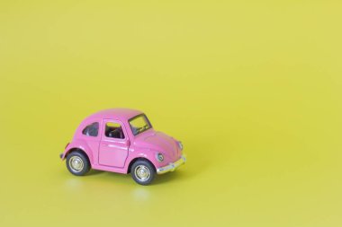 20.07.2021-Zavyalovo.A small pink metal car on a yellow background.