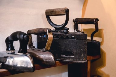 Giysileri ütülemek için klasik ütü koleksiyonu. Antika metal ütüler, antika bir ev aletleri müzesi. Kablosuz metal kömür demiri
