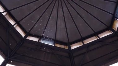 Güneş ışığı içeri düşen karı aydınlatırken kar taneleri kısmen açık çatı penceresinden süzülüyor. Anın güzelliği, duygusal bir an.