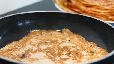 İnce krep tavada kızarırken, dantelli kenarlar gevrek ve altın yüzey eşit derecede pişerken buhar yükselir. Yakın çekim krep dokusu