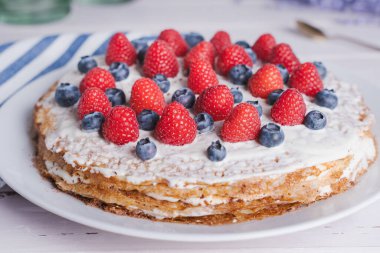 Krema ve çikolata kırıntılarıyla dolu ev yapımı krep, üzerine taze böğürtlen, leziz hafif aile tatlıları.