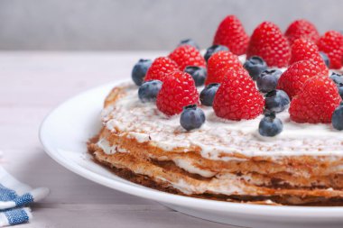 Kremalı ve çikolatalı taze böğürtlenlerle süslenmiş katmanlı krep keki.