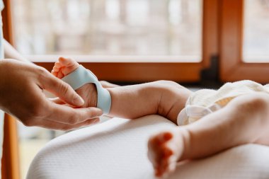 Bakıcı, bebek sağlığı gözlemi, bebek bakımı, bebek sağlığı hizmetleri için bebek ayağına akıllı izleme çorabı takıyor.