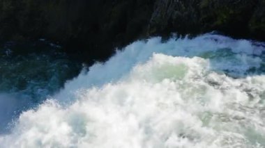 Köpüren nehir akıntıları dalgalanır ve kayalık bir kanyon kanalına çarpar, güçlü bir beyaz su türbülansı, yakın şelale suyu, yavaş çekim
