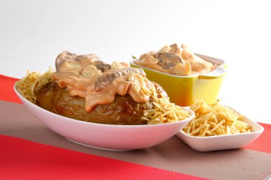 Masadaki beyaz tabağın içinde kremalı fırında patates.