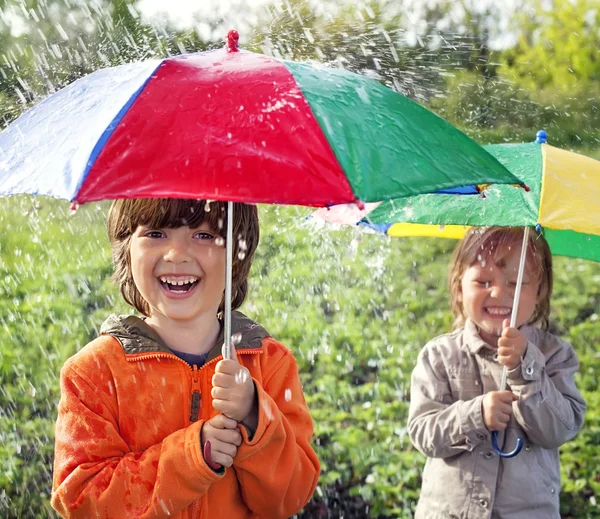 Two happy brother with umbrella outdoors — Stock Photo, Image
