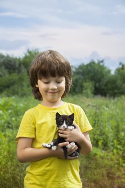 Bir yavru kedi ile mutlu çocuk