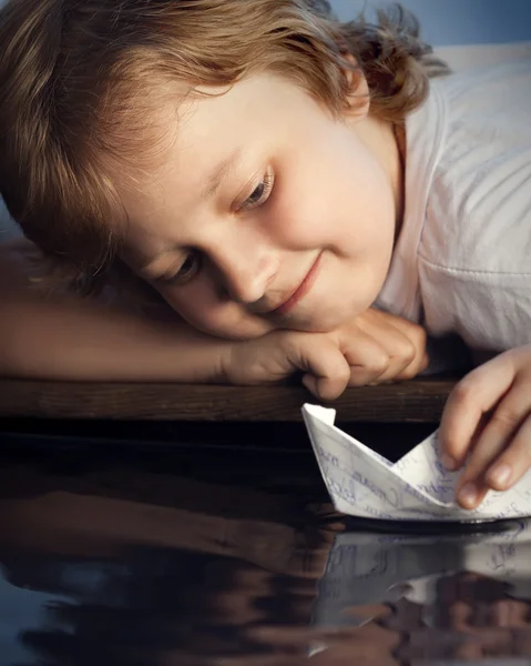 Menino brincando com navio de papel — Fotografia de Stock