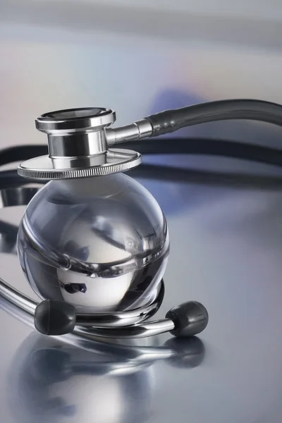 Metal stethoscope on globe — Stock Photo, Image