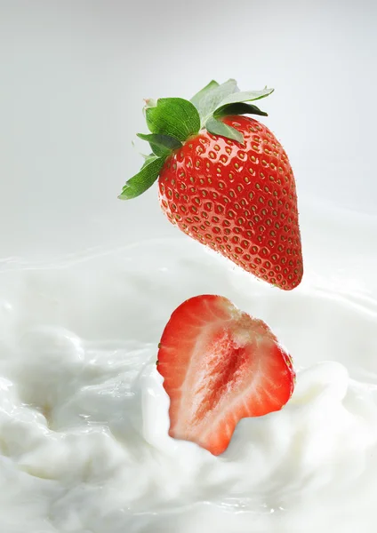 Erdbeeren im Milchspritzer — Stockfoto
