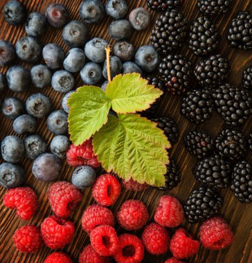 Ahududu ve böğürtlen üzerinde ahşap masa dağınık