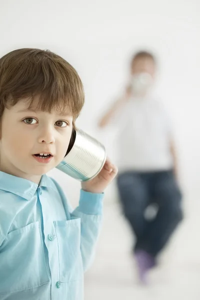 Chłopiec słuchać blaszany telefon — Zdjęcie stockowe