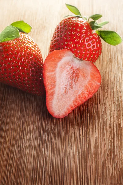 Strawberries lying on wooden table — Stock Photo, Image