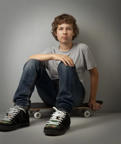 Happy boy sitting on skateboard — Stock Photo, Image