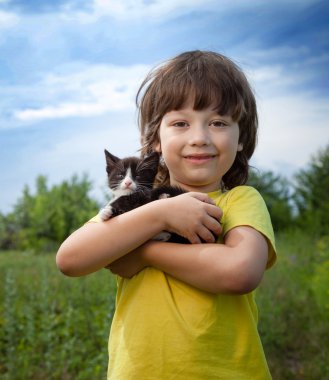 Bir yavru kedi ile mutlu çocuk