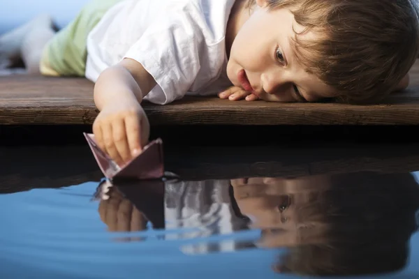 Menino jogar em navio de papel — Fotografia de Stock