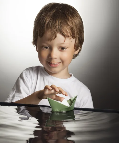 Jongen spelen in papier schip — Stockfoto