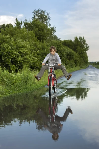 Niño feliz pasando por un charco — Foto de Stock