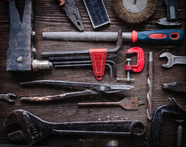 Grungy oud gereedschap op een houten achtergrond (verwerking van cross-proces) — Stockfoto