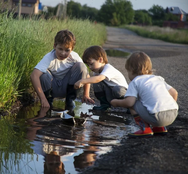 Drei Jungen spielen in Pfütze — Stockfoto