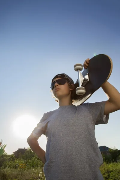 Ung pojke med skateboard i hand — Stockfoto