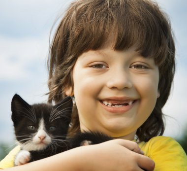 Bir yavru kedi ile mutlu çocuk