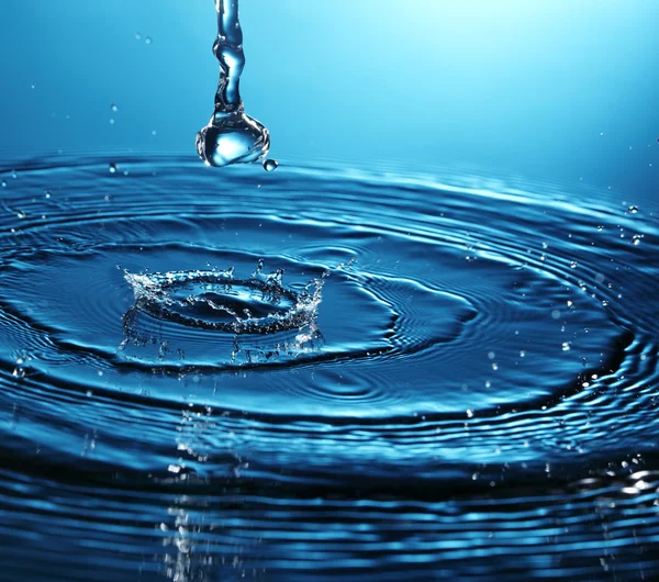 Splash astratto di acqua su sfondo blu — Foto Stock