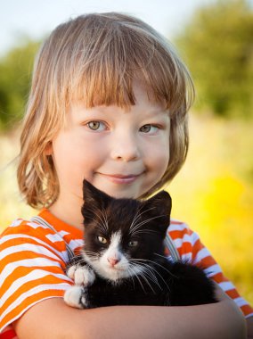Bir yavru kedi ile mutlu çocuk