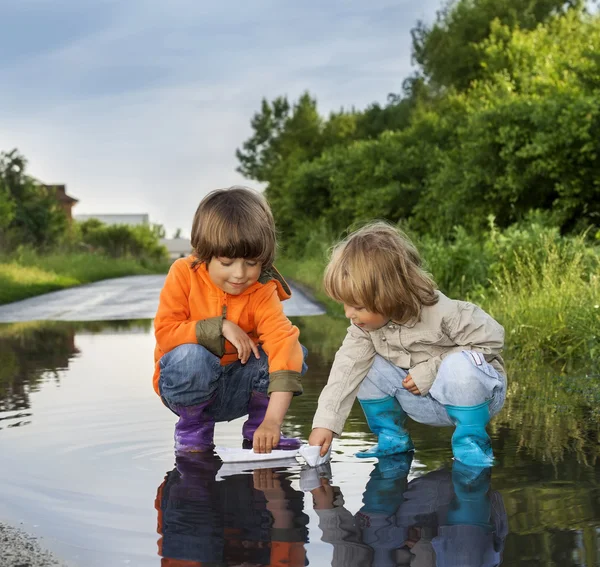 Su birikintisi içinde üç çocuk oyun — Stok fotoğraf