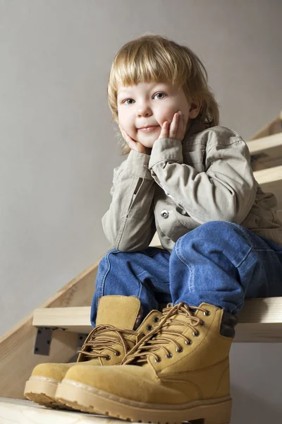 Big shoes to fill child 's feet in large shoe — стоковое фото