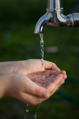 çocuk bahçesinde musluk altından elini yıkar