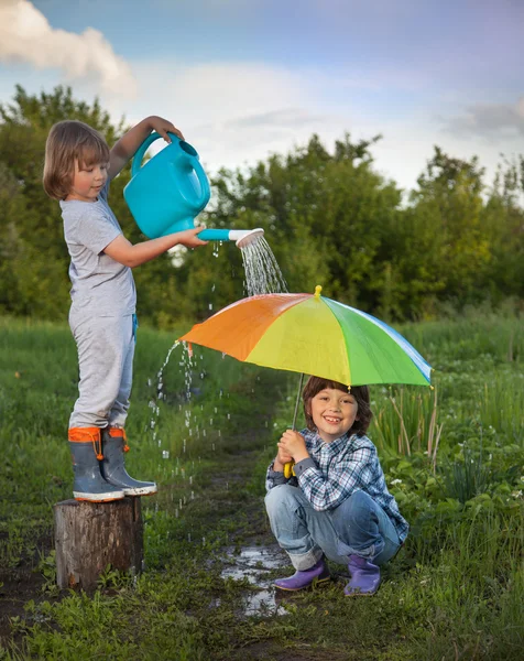 Två bröder leker i regn utomhus — Stockfoto