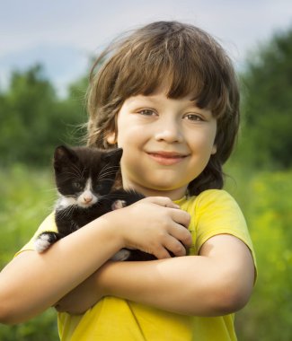 Bir yavru kedi ile mutlu çocuk