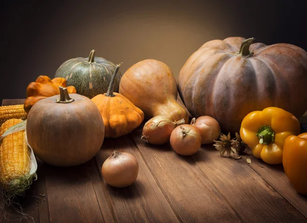 Hösten pumpor och andra frukter och grönsaker på ett träbord — Stockfoto