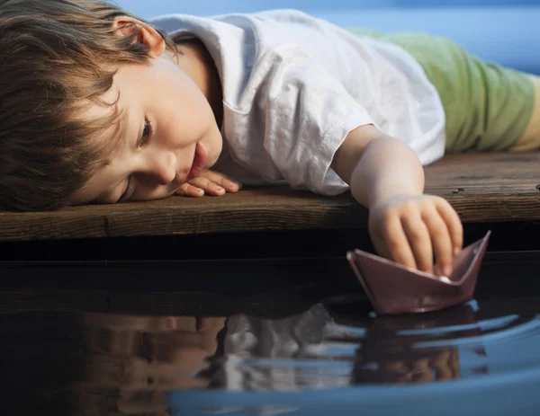 Niño jugar en barco de papel — Foto de Stock