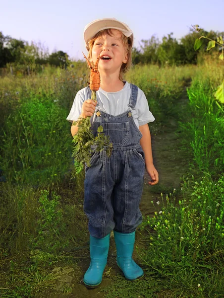 Мальчик с морковкой и лейкой — стоковое фото