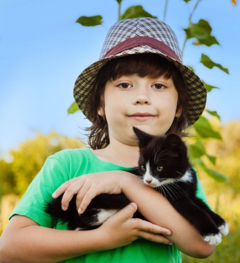 Bir yavru kedi ile mutlu çocuk