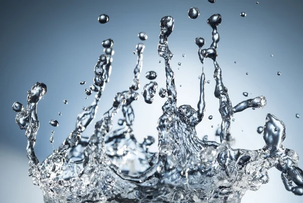 Abstracte druppel water splash op de blauwe achtergrond — Stockfoto