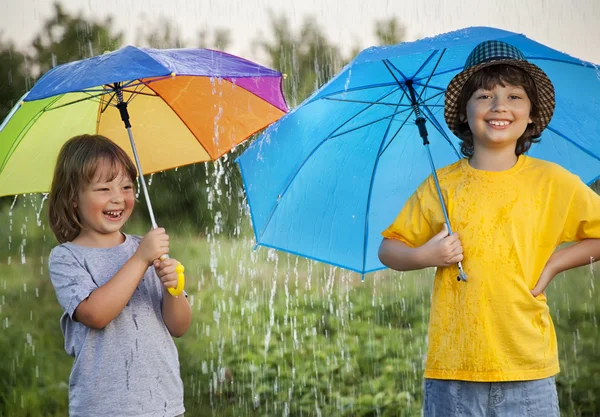 Heureux frères avec des parasols à l'extérieur — Photo