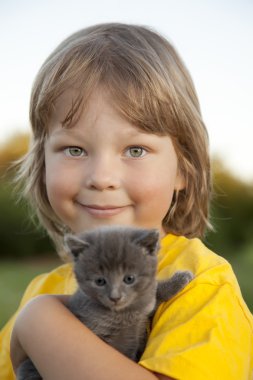 Bir yavru kedi ile mutlu çocuk