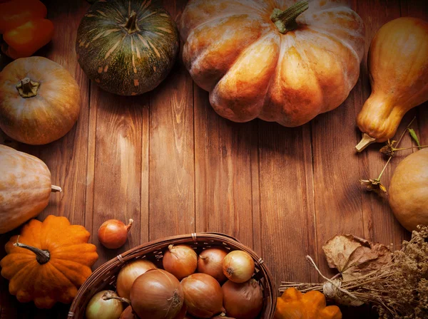Hösten pumpor och andra frukter och grönsaker på ett träbord — Stockfoto