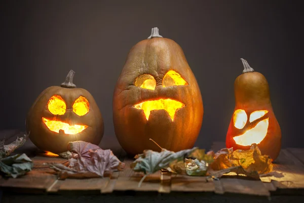 Jack o lanterns Halloween pumpkin face on wooden background — Stock Photo, Image