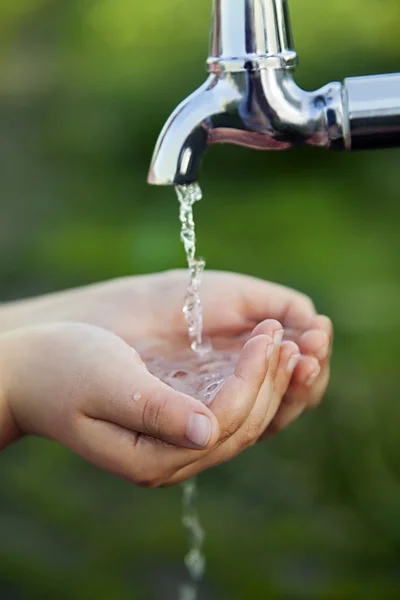 Ragazzo lava la mano sotto il rubinetto in giardino — Foto Stock