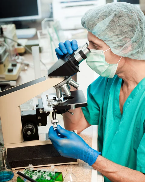 Cientista olhando para um microscópio — Fotografia de Stock