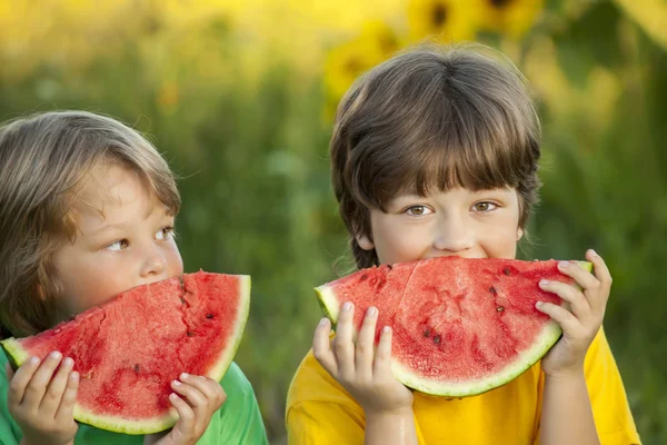 Happy child eating watermelon in garden — Stock Photo, Image