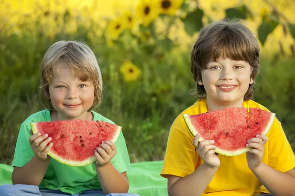 Criança feliz comendo melancia no jardim . — Fotografia de Stock