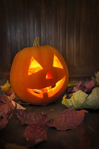 Jack o lanternas Halloween rosto de abóbora no fundo de madeira — Fotografia de Stock