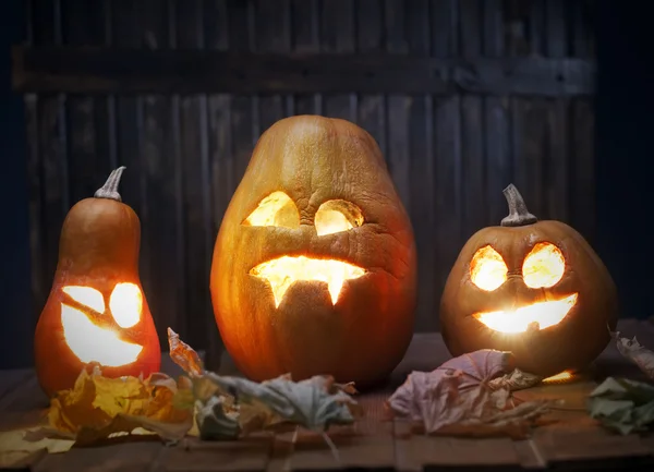 Jack o lanterns Halloween pumpkin face on wooden background — Stock Photo, Image