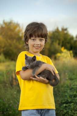 Bir yavru kedi ile mutlu çocuk
