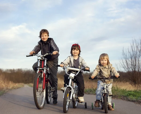 Three brothers ride bikes — Stock Photo, Image